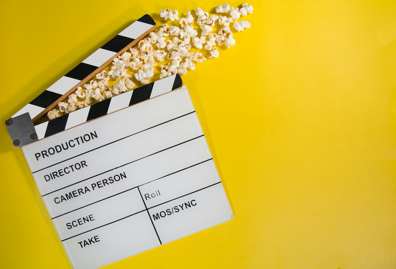 A stylized movie production slate and a vintage film reel